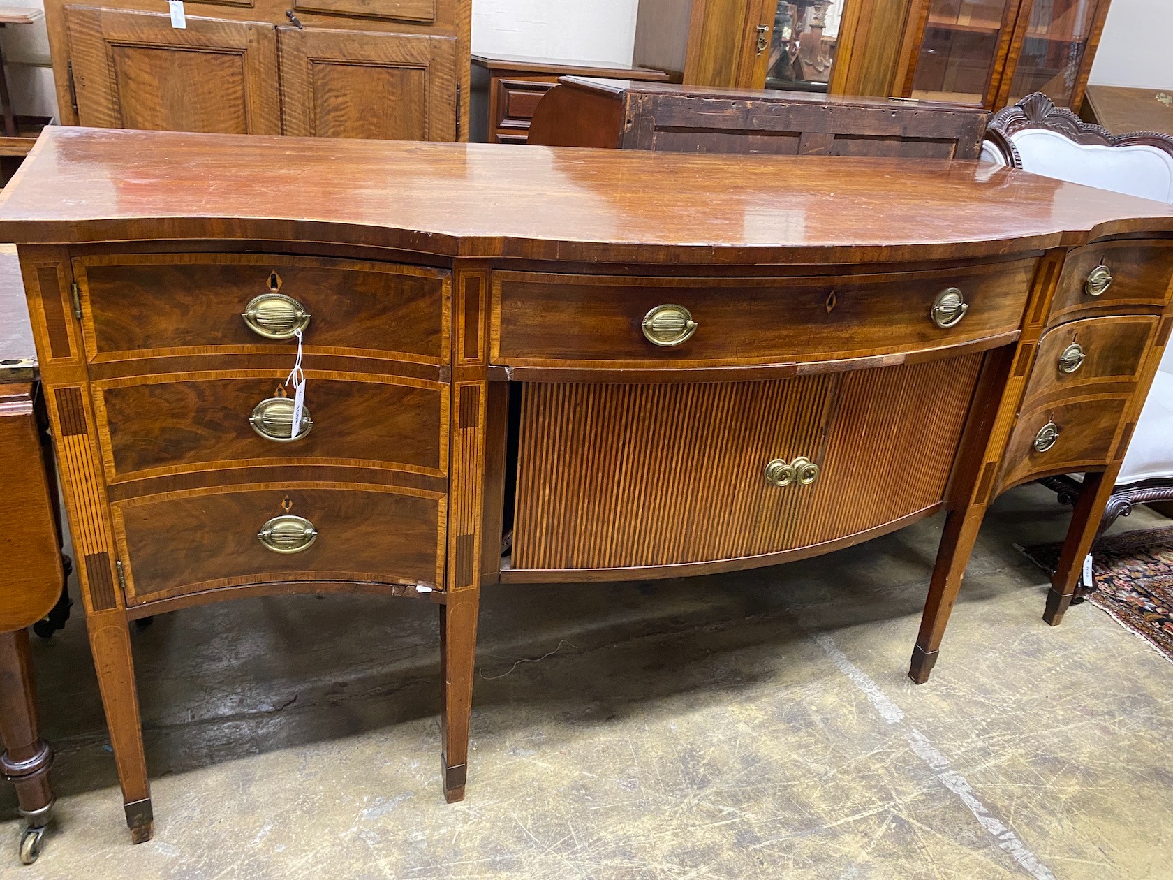 A George III satinwood banded mahogany serpentine sideboard with central tambour compartment, width 199cm, depth 80cm height 95cm